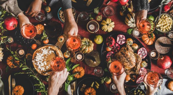 thanksgiving dinner table with pumpkins and food and drinks